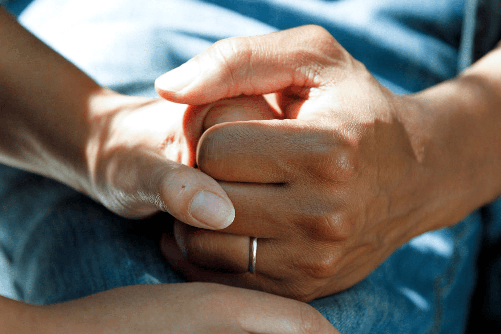 A dialysis expert holding a patient’s hand